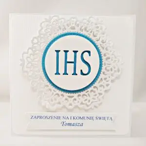 Niebieskie zaproszenie na Pierwszą Komunię Świętą z białym koronkowym ornamentem i symbolem IHS, kwadratowe, eleganckie zaproszenie na papierze wizytówkowym.