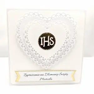 Biało-złote zaproszenie na Pierwszą Komunię Świętą z podwójnym ażurowym sercem i symbolem IHS pośrodku, eleganckie kwadratowe zaproszenie.