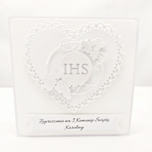 Pojedyncze białe zaproszenie na Pierwszą Komunię Świętą z ażurowym sercem i symbolem IHS w winorośli, na białym papierze wizytówkowym, eleganckie kwadratowe zaproszenie.