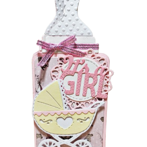 kartka na Baby Shower ręcznie robiona w kształcie butelki w różowych odcieniach z napisem It's a Girl i wózkiem dziecięcym