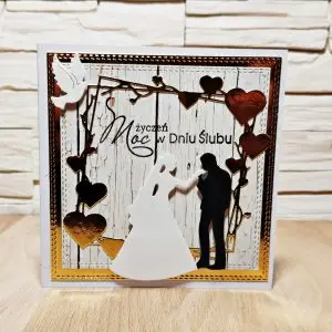 kwadratowa kartka ślubna ręcznie robiona z sylwetką pary młodej i girlandą wiszących serc, elegancka kartka na ślub 13,5x13,5 cm w złoto-białej kolorystyce