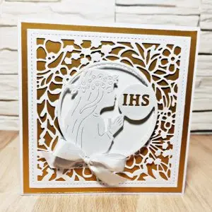 Kwadratowa kartka komunijna 13,5x13,5 dla dziewczynki w biało-złotej kolorystyce, z komunijnym motywem na ażurowym tle, elegancka ręcznie wykonana pamiątka Pierwszej Komunii Świętej