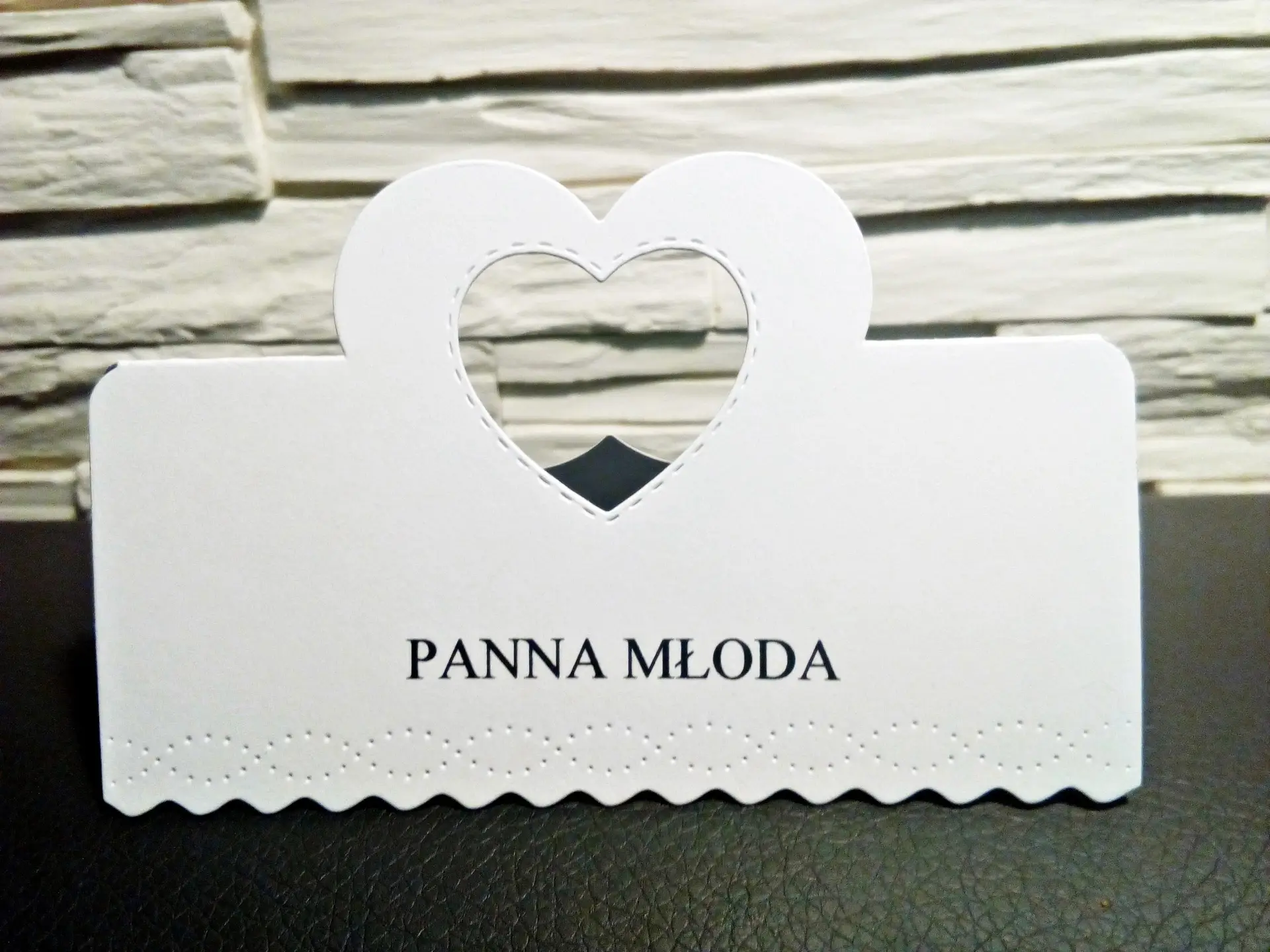 Elegancka winietka ślubna z ażurowym sercem, wykonana ręcznie z białego papieru perłowego, z miejscem na imię gościa