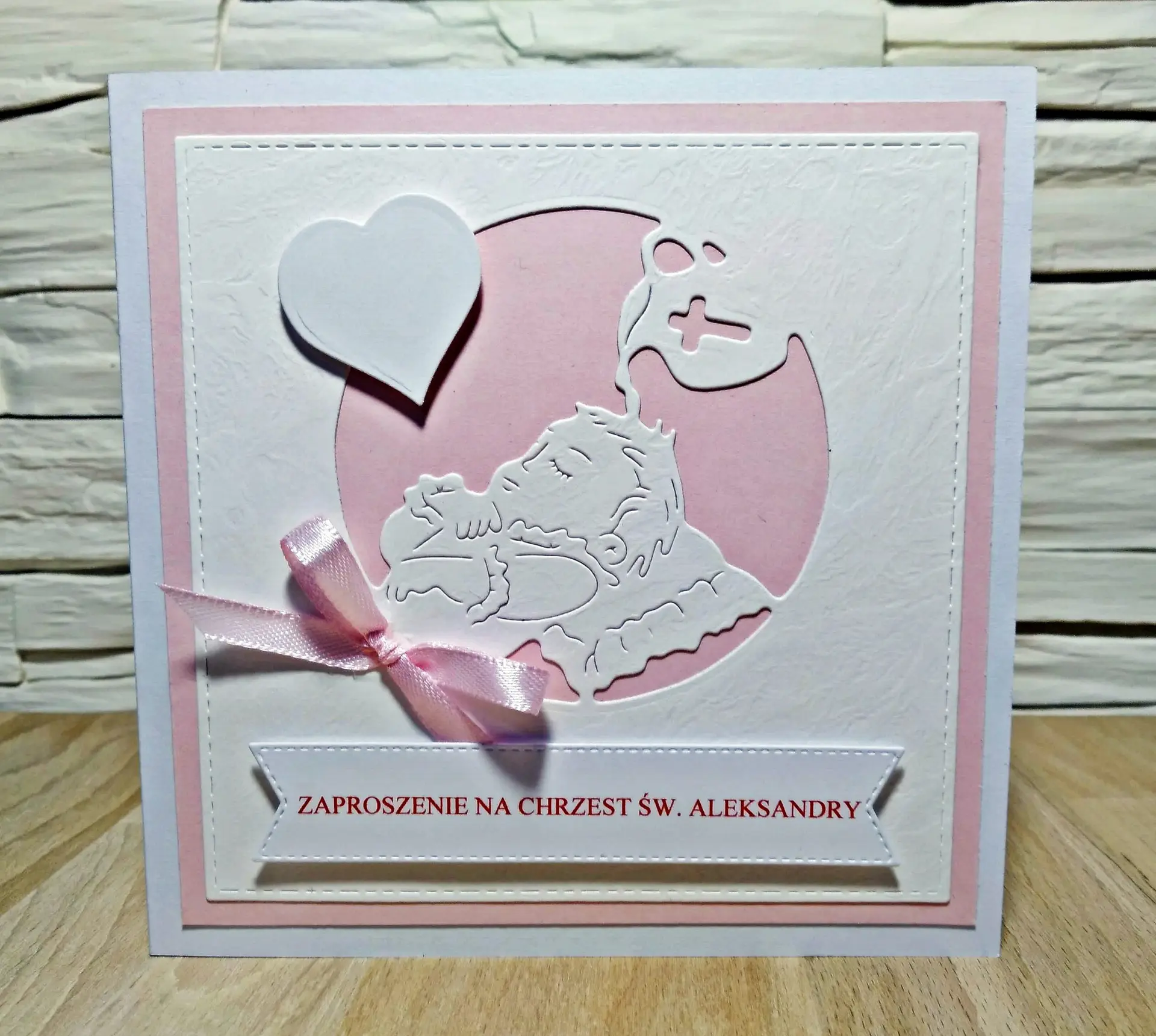 Zaproszenie na Chrzest Święty dziewczynki z motywem chrzczonego dziecka na różowym tle, ręcznie robiona kartka