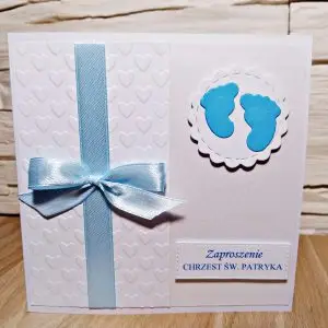Zaproszenie na Chrzest Święty chłopca z motywem dziecięcych stópek, satynową wstążką, tłoczonym tłem w serduszka i błękitnymi detalami na perłowym papierze