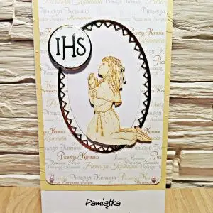 Kartka komunijna DL dla dziewczynki z tekturowym motywem klęczącej, modlącej się dziewczynki i napisem „Pamiątka Pierwszej Komunii Świętej”, eleganckie tło i delikatne zdobienia