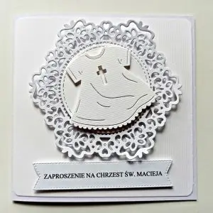 Uniwersalne zaproszenie na Chrzest Święty z motywem białej szatki do chrztu na tle koronki, całe w bieli, ręcznie robione zaproszenie
