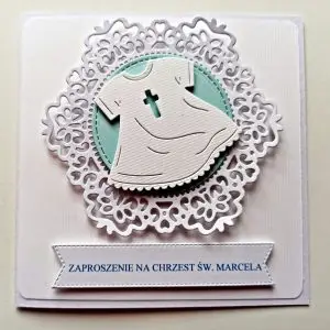 Zaproszenie na Chrzest Święty chłopca z motywem białej szatki do chrztu na tle koronki z niebieskim detalem, elegancka kartka handmade