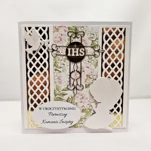 Ręcznie robiona kartka komunijna 13,5x13,5 z klęczącą dziewczynką w sukience komunijnej i napisem „W uroczystym dniu Pierwszej Komunii Świętej”, eleganckie zdobienia i delikatne kolory