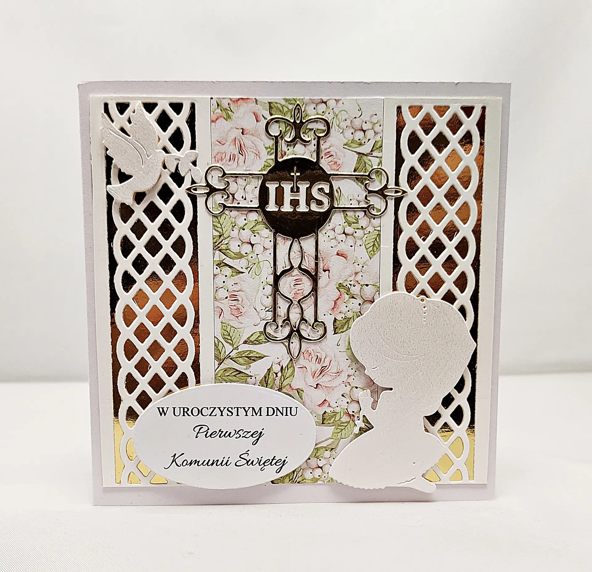 Ręcznie robiona kartka komunijna 13,5x13,5 z klęczącą dziewczynką w sukience komunijnej i napisem „W uroczystym dniu Pierwszej Komunii Świętej”, eleganckie zdobienia i delikatne kolory