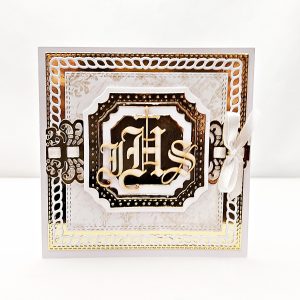 Ręcznie robiona kartka komunijna z tekturką IHS i ozdobną kieszonką na pieniężny upominek lub voucher, utrzymana w bieli i beżach, z eleganckim ażurowym motywem