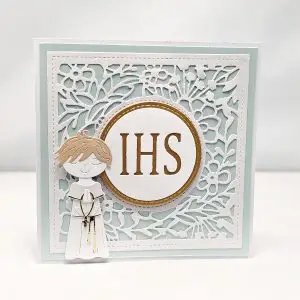 Ręcznie robiona kartka komunijna dla chłopca w odcieniach błękitu, z motywem IHS i postacią chłopca w albie