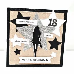 Ręcznie robiona kartka na 18 urodziny dla dziewczyny w czerni, złotym różu i srebrze, z dużą błyszczącą gwiazdą, sylwetką dziewczyny oraz napisami „spełniaj marzenia”, „sięgaj gwiazd”, „sto lat” i „W dniu 18 urodzin”