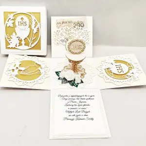 Ręcznie robiony exploding box na I Komunię Świętą w białokremowej kolorystyce ze złotymi dodatkami, otwarte pudełko z kielichem 3D w środku i dekoracyjnymi ściankami