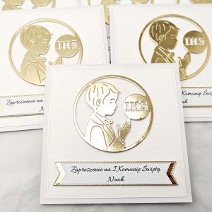 Trzy biało-złote zaproszenia komunijne dla chłopca z sylwetką chłopca i IHS, bez złotego tła, sfotografowane z góry w prostej kompozycji.