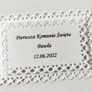 Biała ażurowa etykieta na ciasto w kształcie prostokąta, ręcznie robiony bilecik z imieniem i datą uroczystości, podziękowanie dla gości