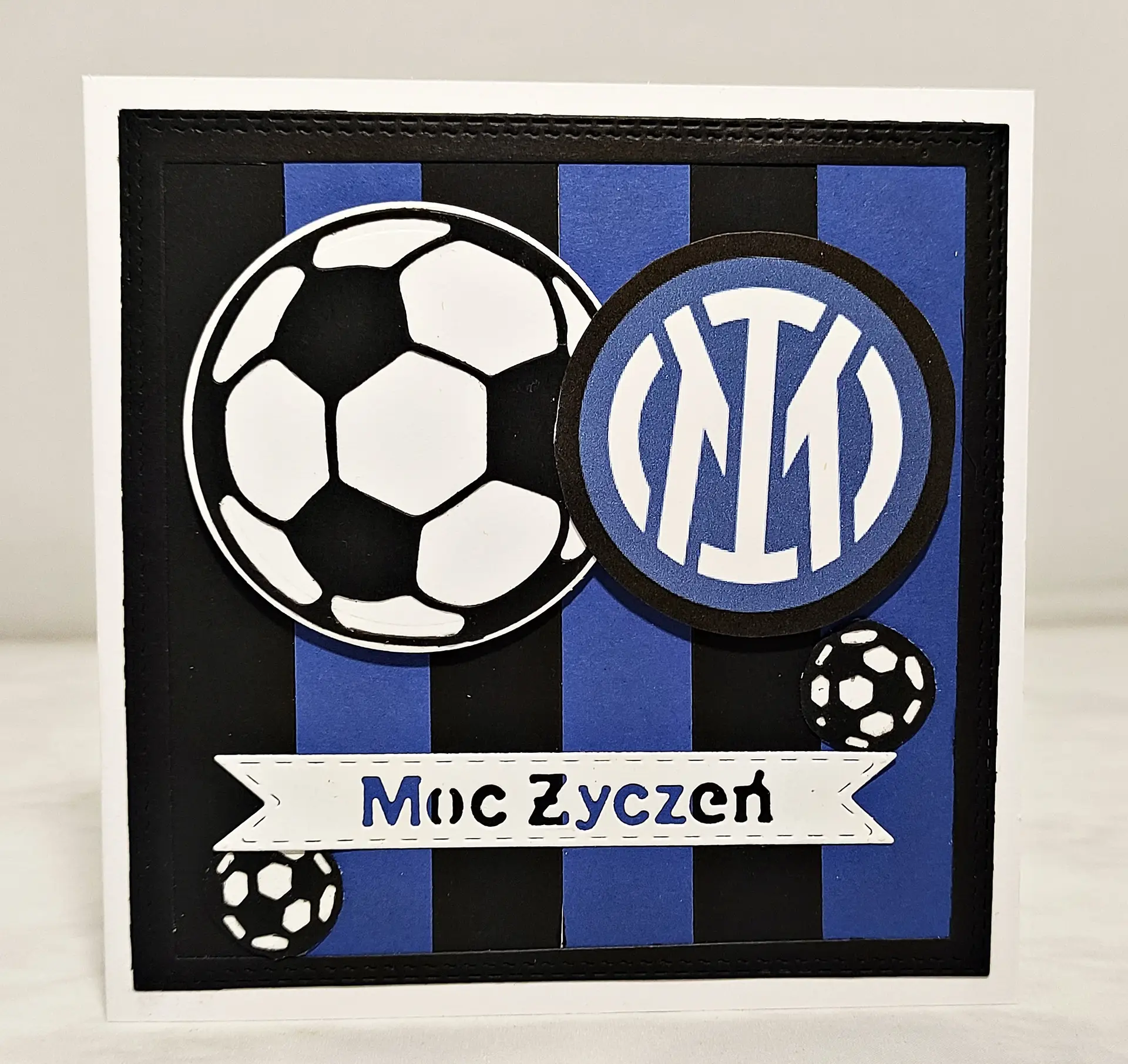 Ręcznie robiona kartka piłkarska Inter Mediolan w pionowe czarno-niebieskie paski z herbem klubu, motywem piłek i napisem „Moc życzeń” idealna na urodziny dla kibica