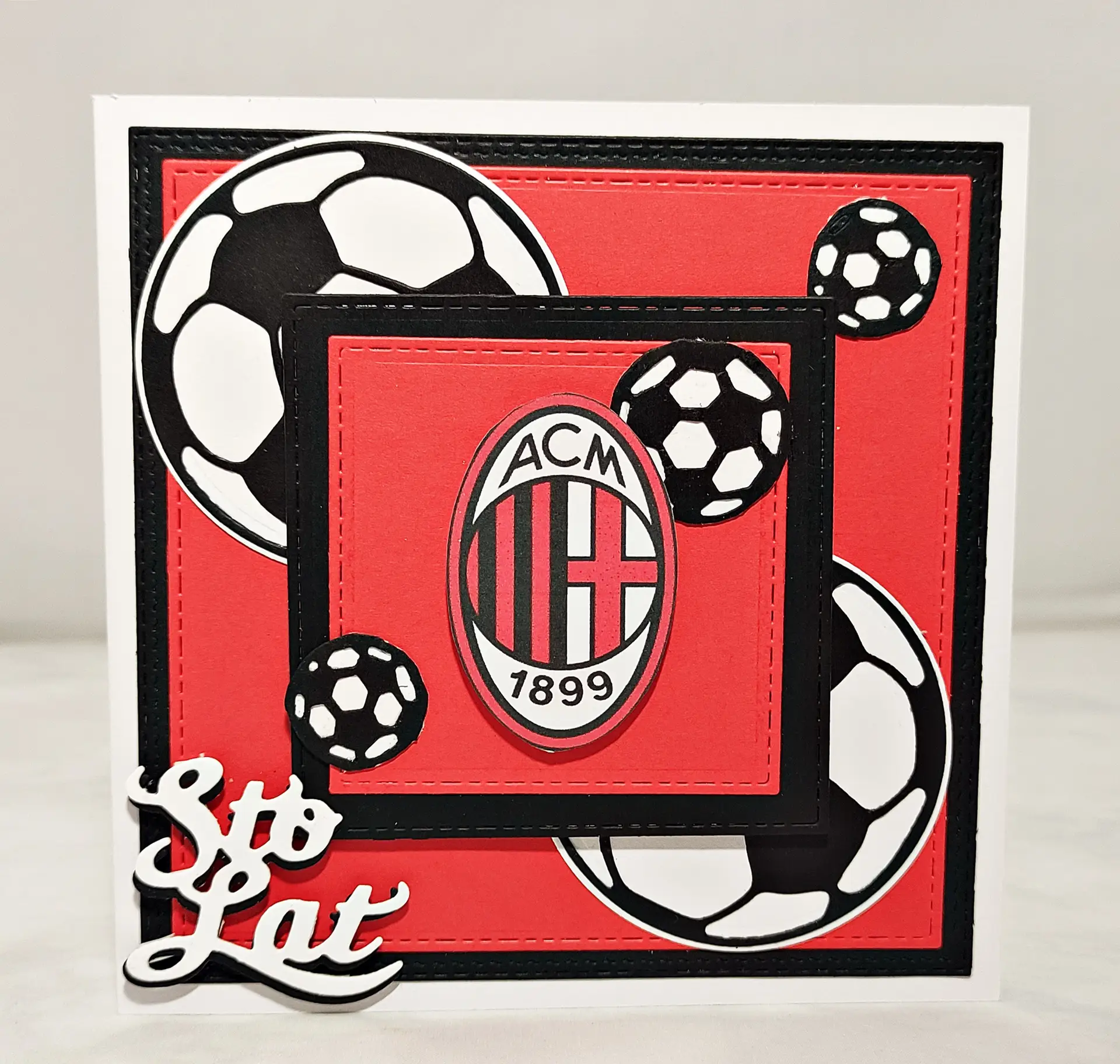 Ręcznie robiona kartka piłkarska w czerwono-czarnych barwach AC Milan z herbem klubu, motywem piłek i napisem urodzinowym jako oryginalny prezent dla fana