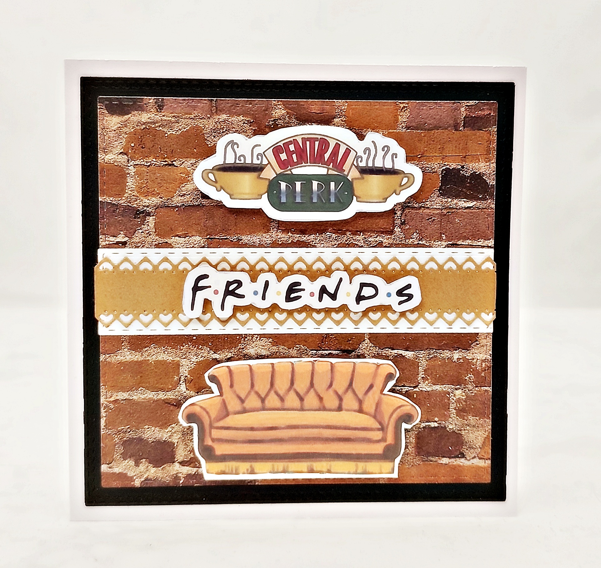 Ręcznie robiona kartka urodzinowa z motywem Friends, sofa i logo Central Perk na tle ceglanej ściany