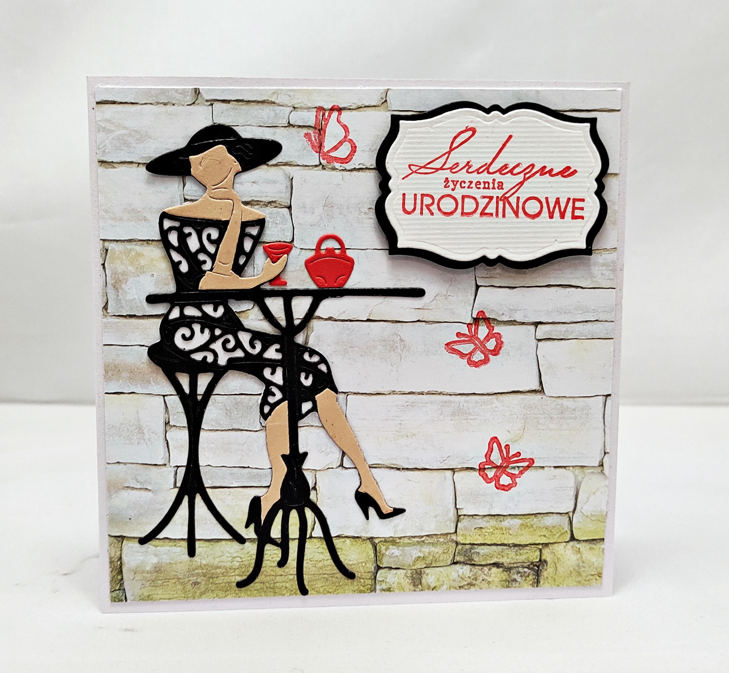 Ręcznie robiona elegancka kartka urodzinowa z kobietą przy stoliku kawiarnianym, format 13,5x13,5 cm, z napisem „Serdeczne życzenia urodzinowe”, w komplecie z kopertą